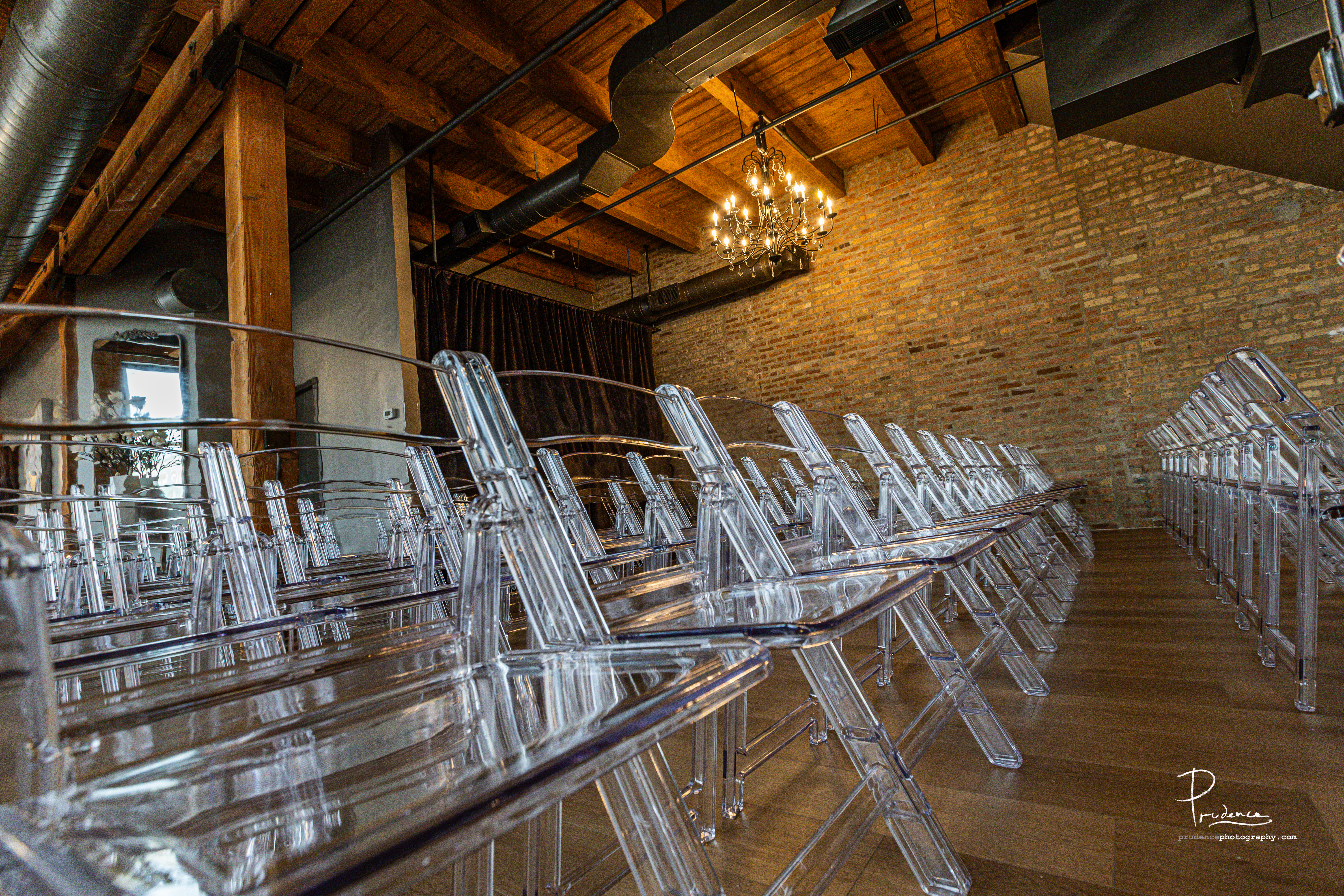 Rows of clear acrylic chairs set for a ceremony inside the industrial loft venue